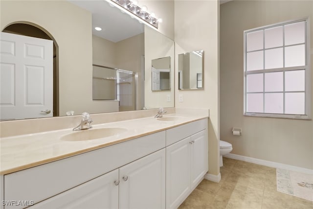 bathroom with vanity, toilet, walk in shower, and tile patterned floors