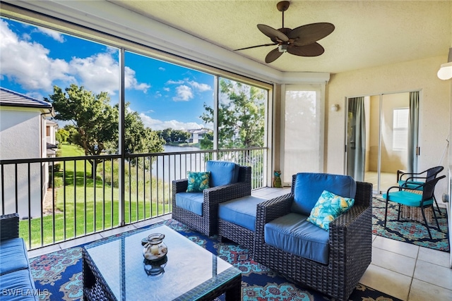 sunroom / solarium featuring a water view and ceiling fan