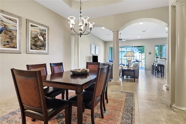 tiled dining room featuring ceiling fan with notable chandelier and ornate columns