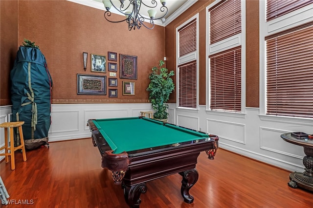 playroom with billiards, ornamental molding, hardwood / wood-style flooring, and a notable chandelier