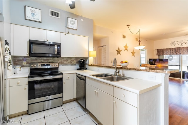 kitchen featuring kitchen peninsula, sink, light wood-type flooring, white cabinetry, and appliances with stainless steel finishes