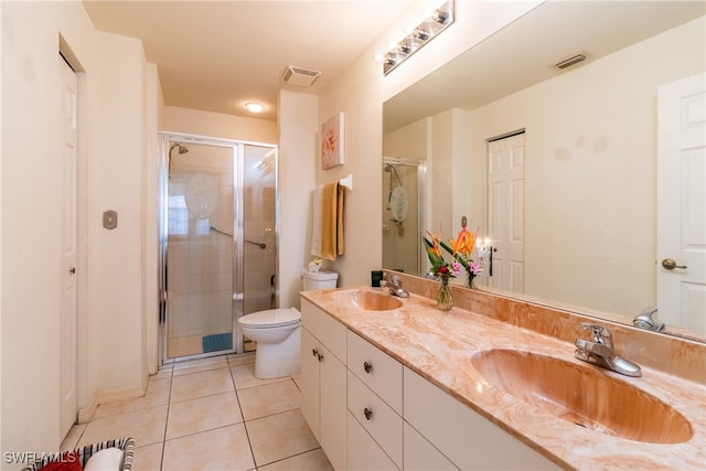 bathroom with toilet, vanity, tile patterned floors, and a shower with door