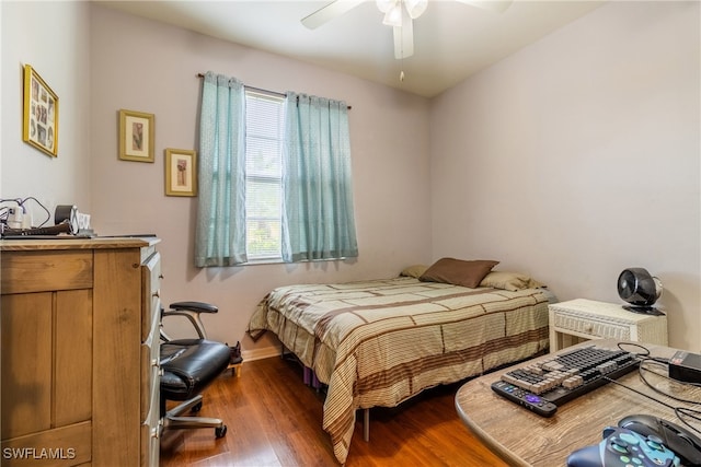 bedroom with dark hardwood / wood-style floors and ceiling fan