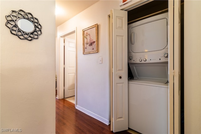 washroom with stacked washer / dryer and dark hardwood / wood-style flooring