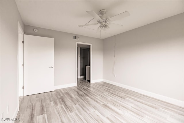 empty room with ceiling fan and light wood-type flooring