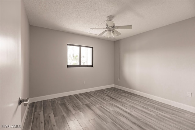 empty room with a textured ceiling, hardwood / wood-style floors, and ceiling fan