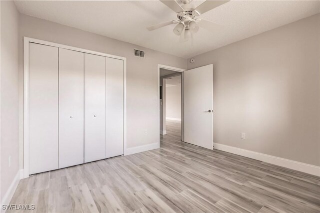 unfurnished bedroom with light wood-type flooring, a closet, and ceiling fan