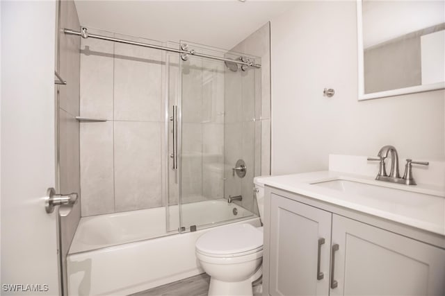 full bathroom with vanity, toilet, wood-type flooring, and enclosed tub / shower combo