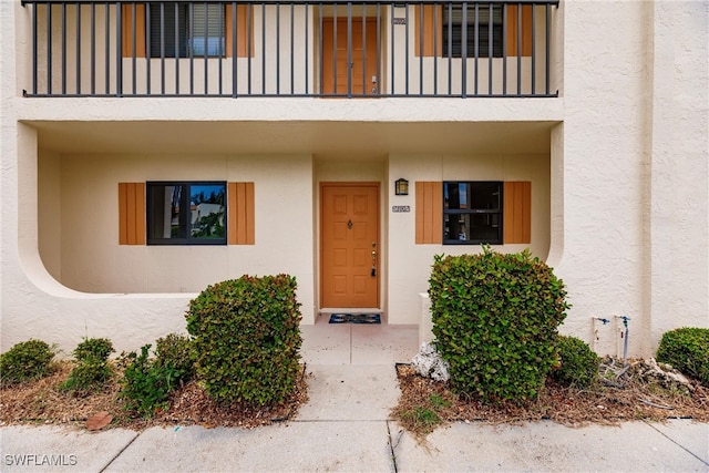 view of exterior entry with a balcony