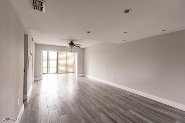 unfurnished room with dark hardwood / wood-style flooring and ceiling fan