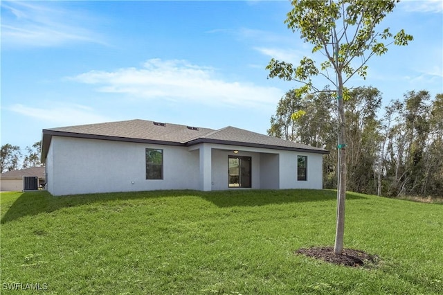 rear view of house featuring a garage, a lawn, stucco siding, and central air condition unit