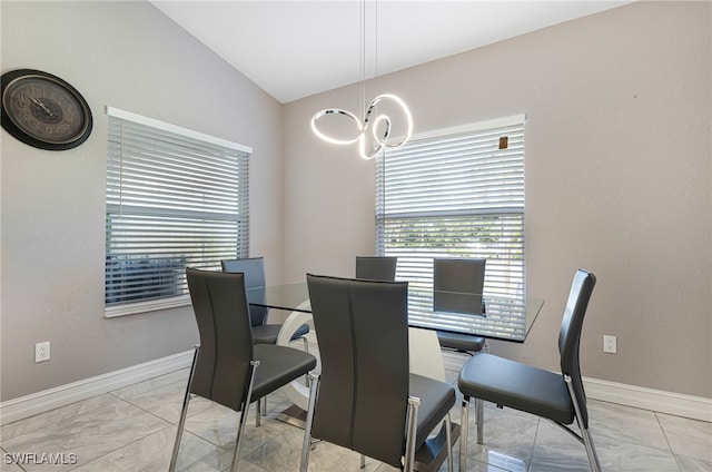 dining area featuring lofted ceiling, light tile patterned flooring, and a chandelier