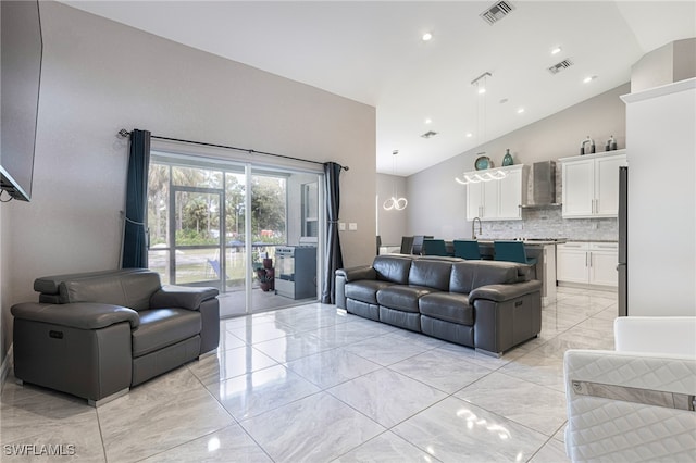 living room featuring sink, vaulted ceiling, and light tile patterned flooring