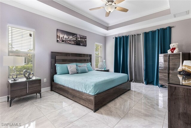 tiled bedroom featuring ceiling fan, crown molding, multiple windows, and a tray ceiling