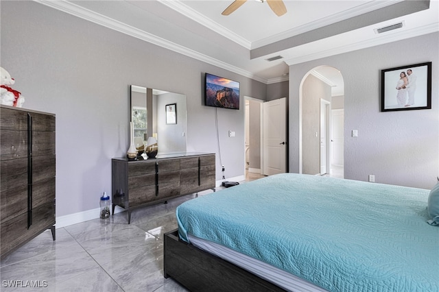 tiled bedroom with ceiling fan, a raised ceiling, crown molding, and ensuite bath