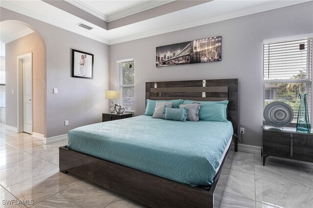 tiled bedroom with a tray ceiling, crown molding, and multiple windows