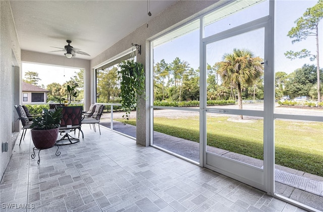 unfurnished sunroom with ceiling fan