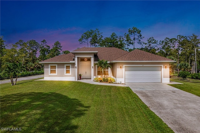 view of front of house featuring a garage and a yard