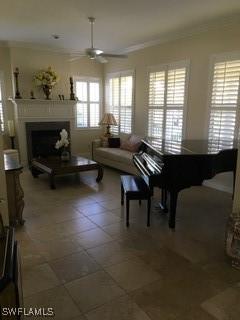 living room featuring tile patterned flooring, ceiling fan, and crown molding