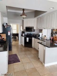 kitchen featuring light tile patterned floors, white cabinetry, and electric range