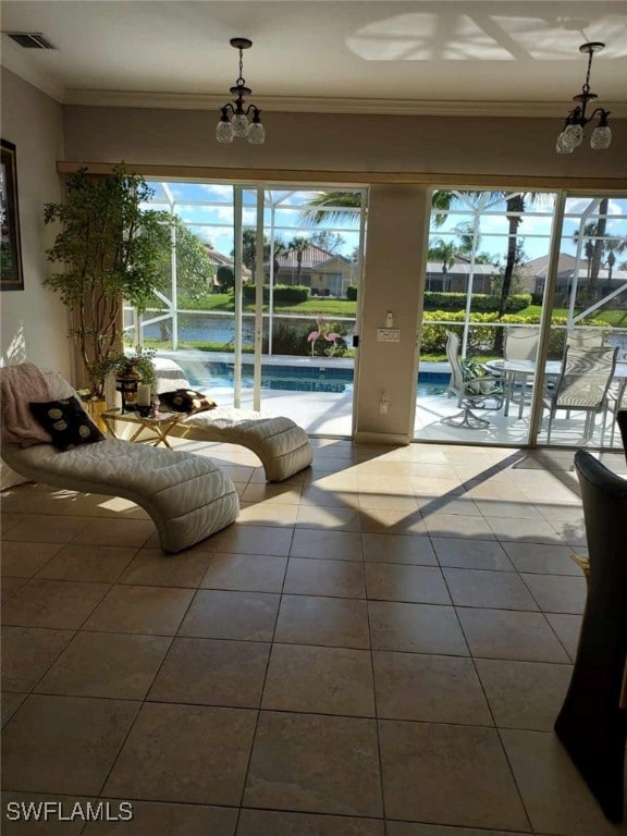 interior space featuring ornamental molding, plenty of natural light, an inviting chandelier, and a water view