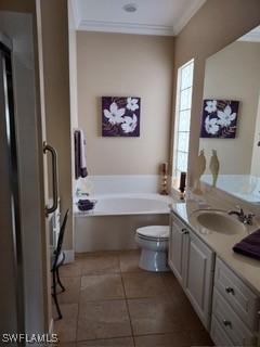 bathroom with ornamental molding, tile patterned flooring, vanity, a washtub, and toilet