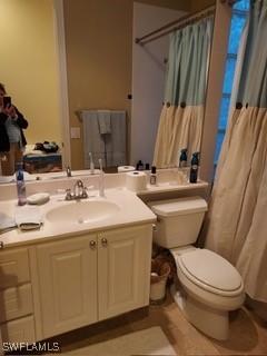 bathroom with toilet, walk in shower, and vanity