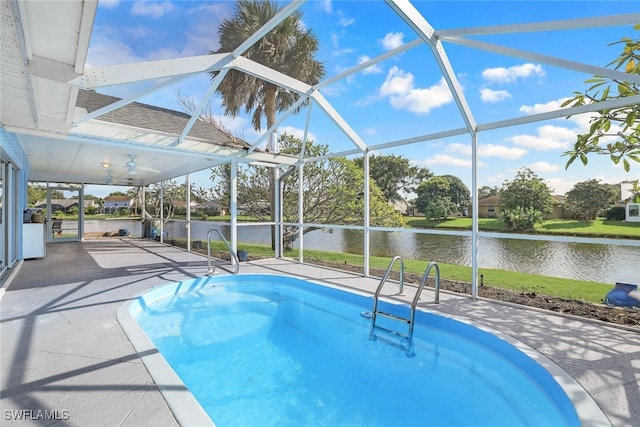 view of pool with a patio area, glass enclosure, and a water view