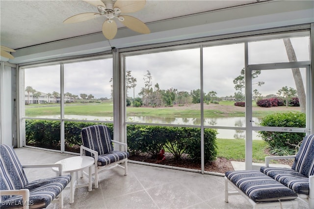 sunroom / solarium with ceiling fan, plenty of natural light, and a water view