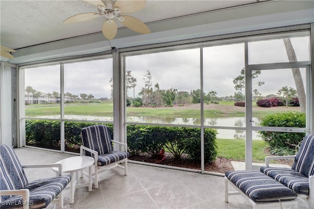 sunroom / solarium featuring a water view and ceiling fan