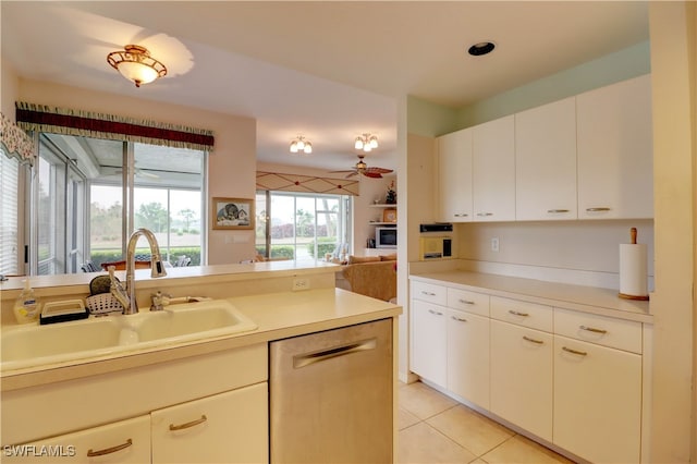 kitchen with white cabinets, sink, light tile patterned floors, and stainless steel dishwasher