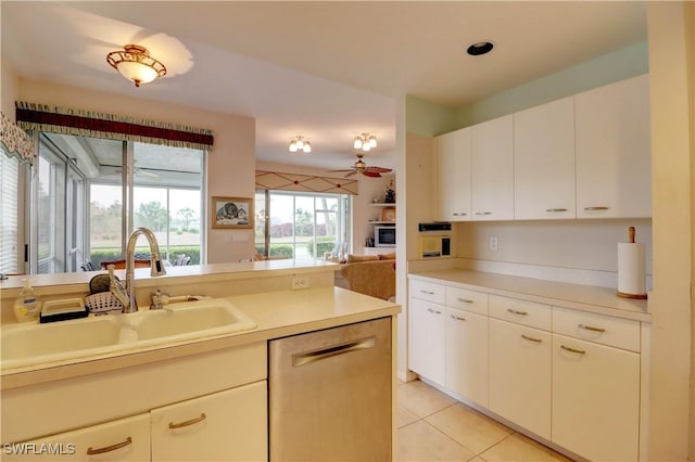 kitchen featuring light tile patterned floors, a ceiling fan, open floor plan, a sink, and dishwasher