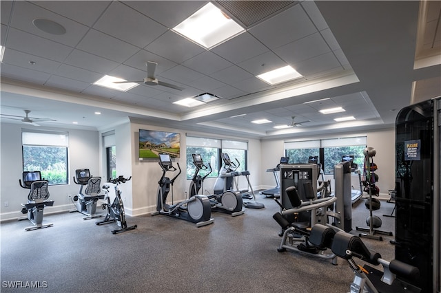 gym with ceiling fan, a tray ceiling, a drop ceiling, and ornamental molding