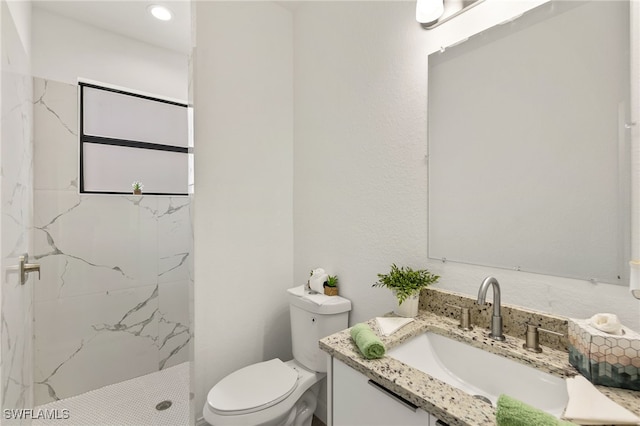 bathroom featuring vanity, a marble finish shower, and toilet