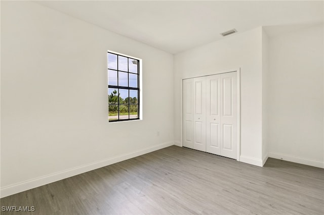 unfurnished bedroom featuring a closet and hardwood / wood-style flooring