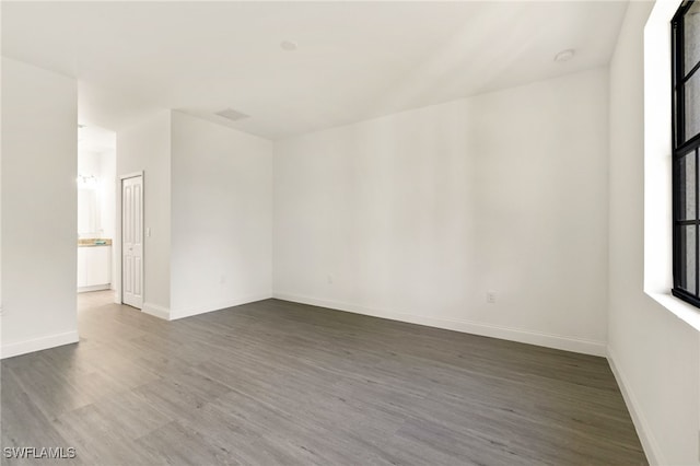 unfurnished room with dark wood-type flooring