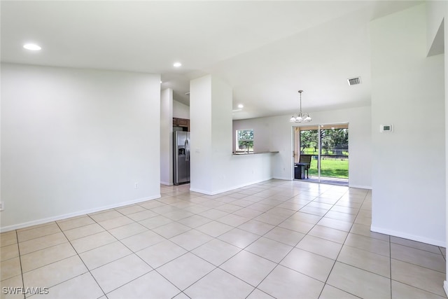 unfurnished living room featuring lofted ceiling, light tile patterned floors, and a notable chandelier