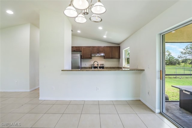 kitchen featuring hanging light fixtures, vaulted ceiling, stainless steel appliances, and a healthy amount of sunlight