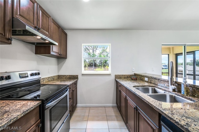 kitchen with light tile patterned flooring, appliances with stainless steel finishes, sink, and light stone counters