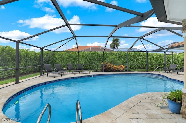 view of swimming pool with glass enclosure and a patio