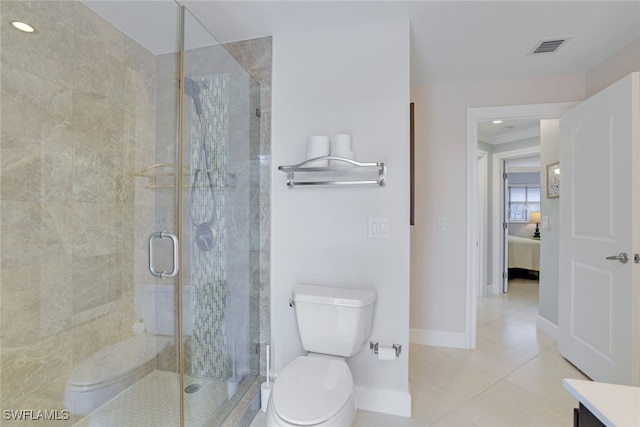 bathroom featuring tile patterned flooring, a shower with shower door, toilet, and vanity