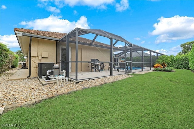 back of house with a yard, a patio area, and glass enclosure