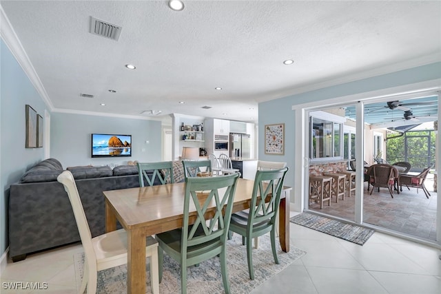 tiled dining space with crown molding and a textured ceiling