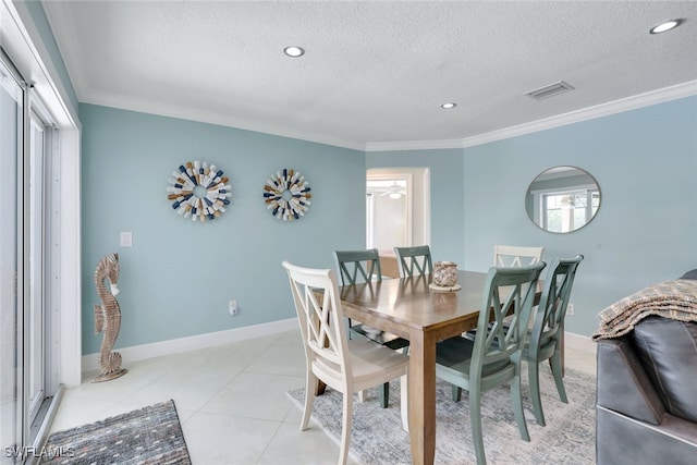 tiled dining space featuring crown molding and a textured ceiling