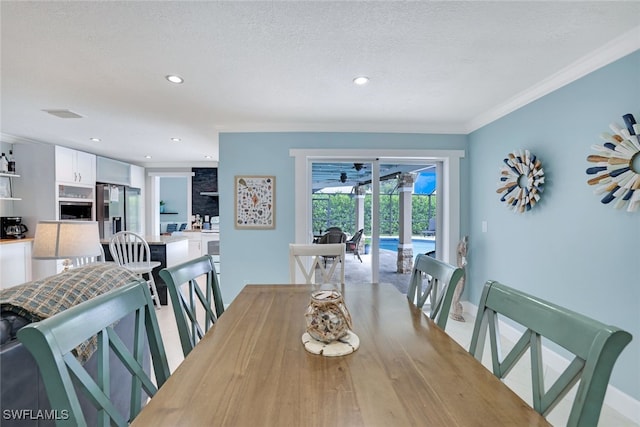 dining area featuring a textured ceiling and ornamental molding