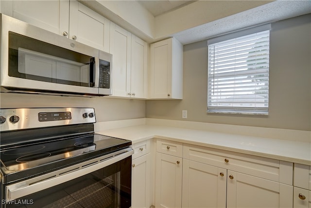 kitchen featuring stainless steel appliances and white cabinetry