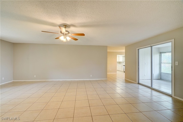 tiled spare room featuring a textured ceiling and ceiling fan