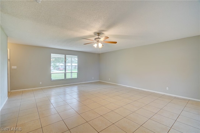 tiled spare room with a textured ceiling and ceiling fan