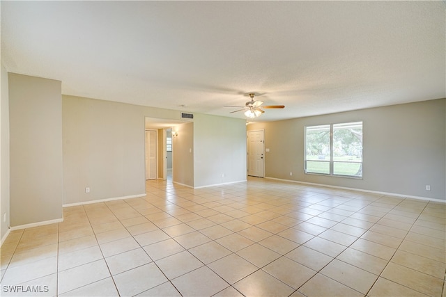 unfurnished room with ceiling fan, light tile patterned flooring, and a textured ceiling