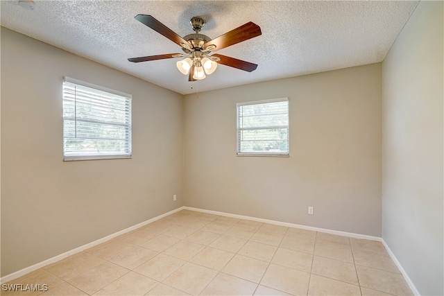 tiled spare room with ceiling fan and a textured ceiling